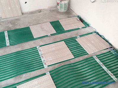 Electric underfloor heating with your hands under the tile, laminate