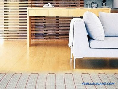 Electric underfloor heating with your hands under the tile, laminate